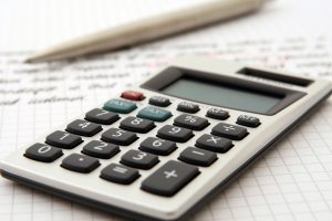 Pen and a Calculator on a Table | Breast Cancer Car Donations