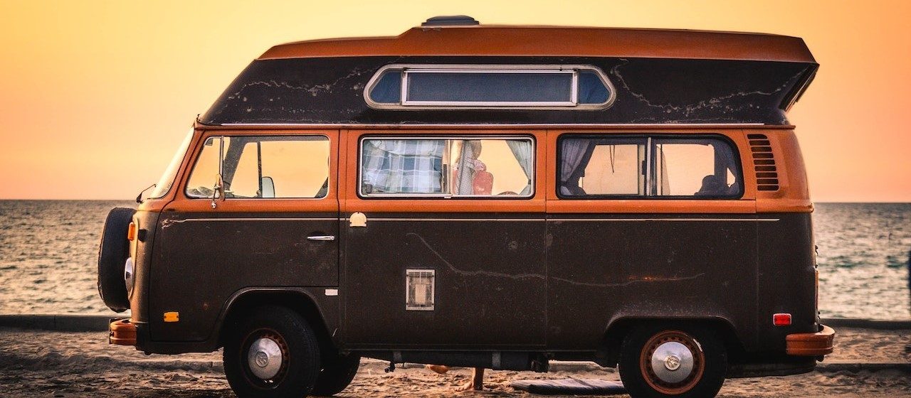 Brown RV parked near the beach during sunset | Breast Cancer Car Donations