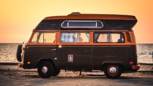 Brown RV parked near the beach during sunset | Breast Cancer Car Donations