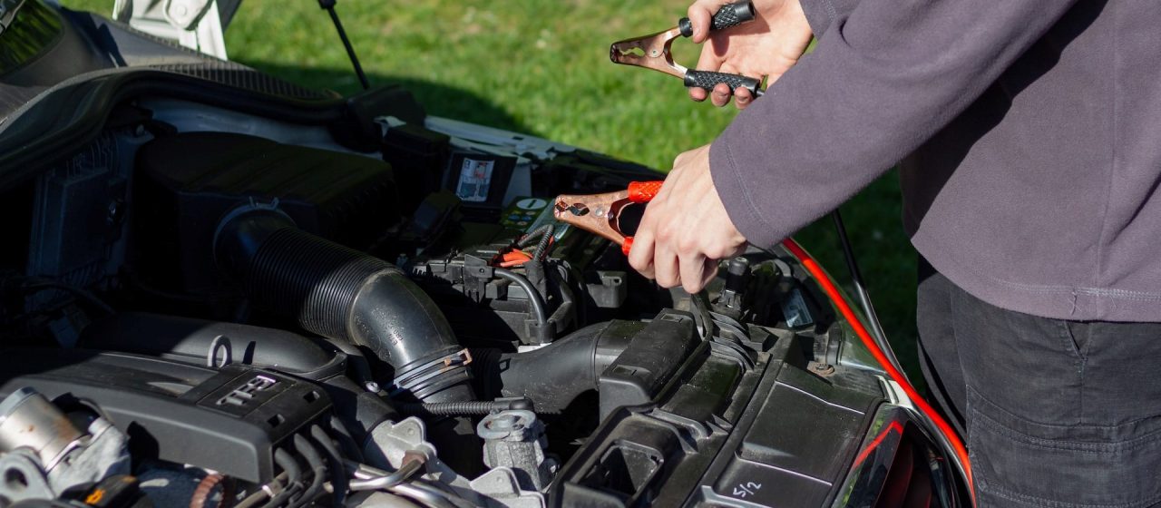 Man holding an battery jumper cable | Breast Cancer Car Donations