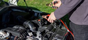 Man holding an battery jumper cable | Breast Cancer Car Donations