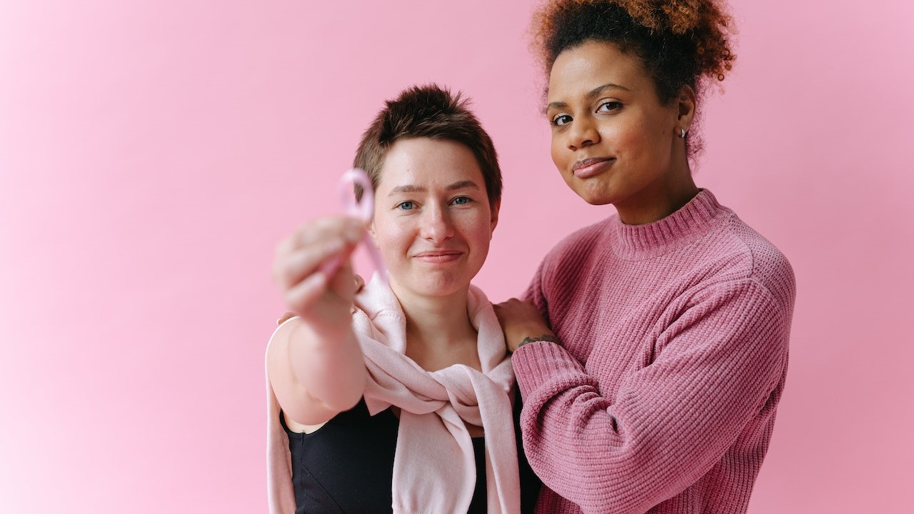 Woman holding a pink ribbon | Breast Cancer Car Donations