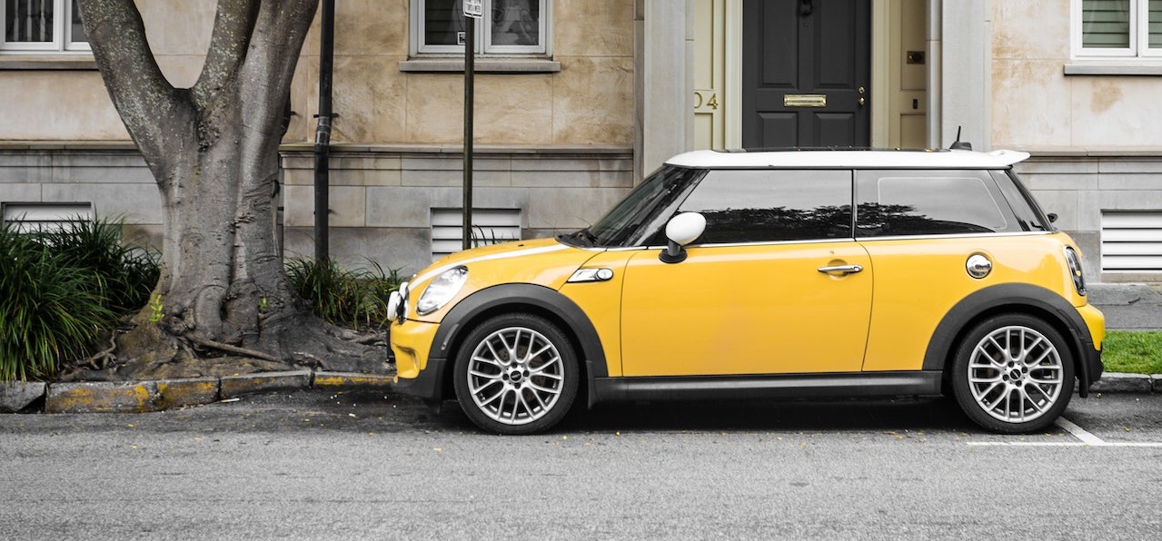 Yellow mini cooper parked on the side of the road | Breast Cancer Car Donations