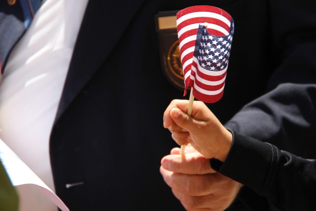 US Veteran with a Kid Holding the US Flag | Breast Cancer Car Donations