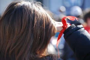 Woman Wearing Red Ribbon to Promote HIV AIDS | Breast Cancer Car Donations