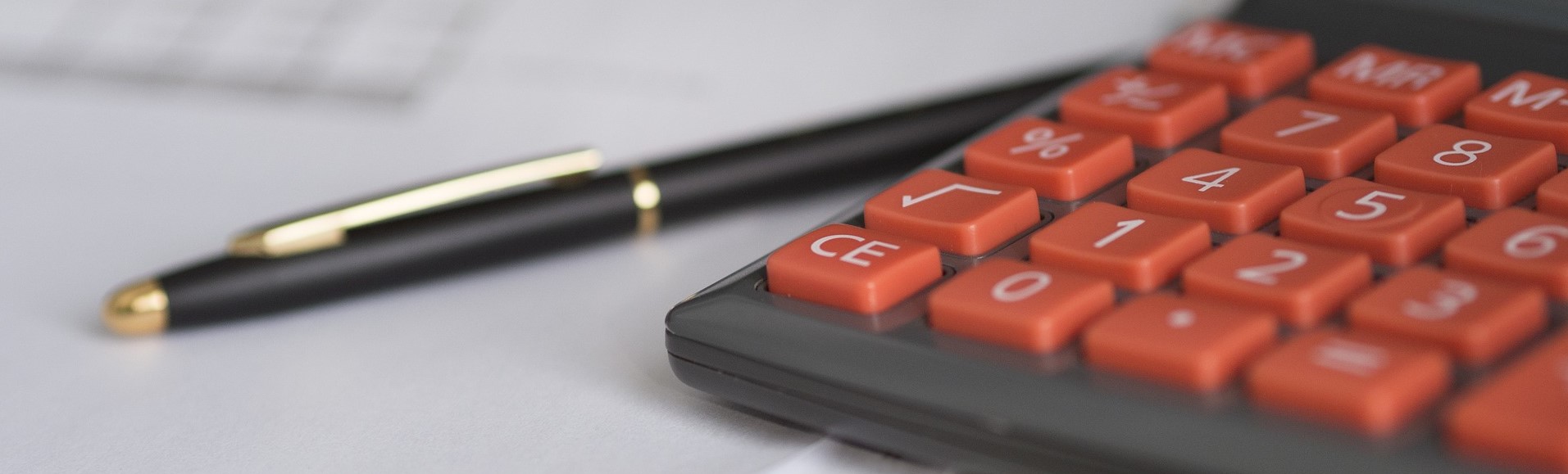 Pen and Calculator on a Table | Breast Cancer Car Donations