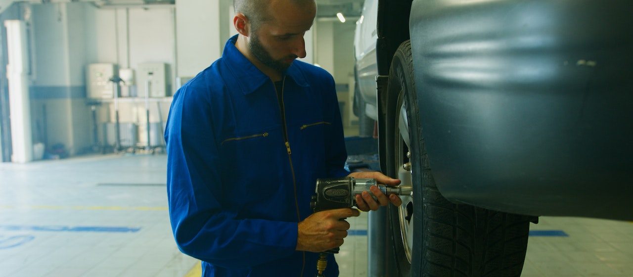 Mechanic Removing a Tire | Breast Cancer Car Donations