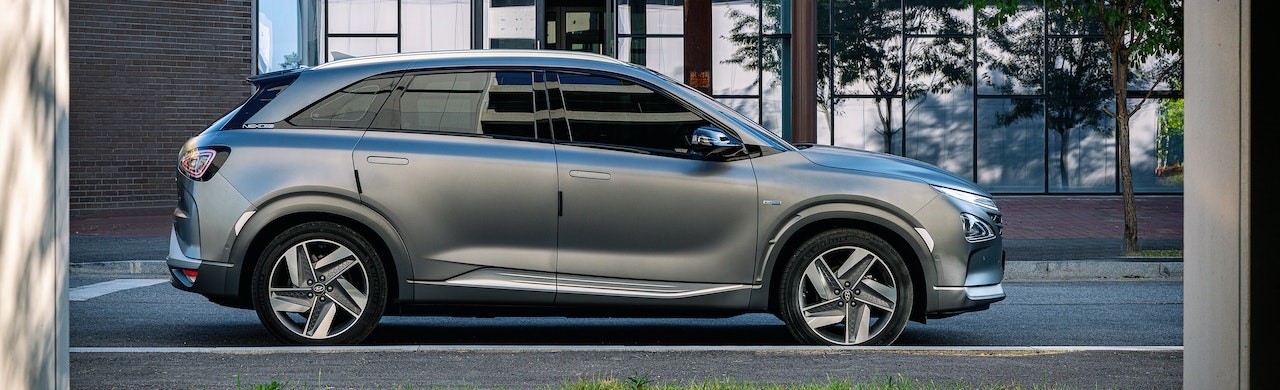 Side View Shot of Gray SUV Parked Near Glass Building | Breast Cancer Car Donations