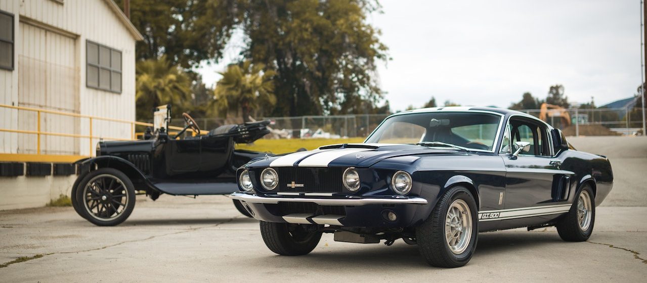 Two Black Vintage Cars Parked Near a Building | Breast Cancer Car Donations