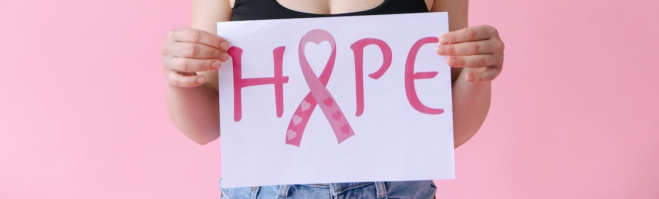 Woman in Black Tank Top Holding a Hope Sign Symbol for Breast Cancer | Breast Cancer Car Donations