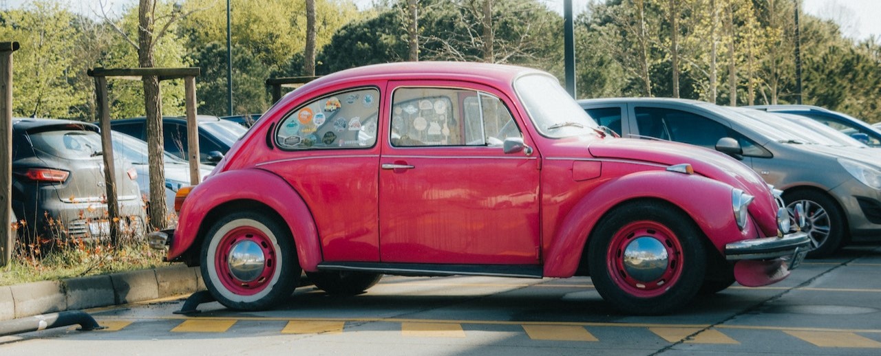 A Pink Volkswagen Beetle in a Parking Lot | Breast Cancer Car Donations