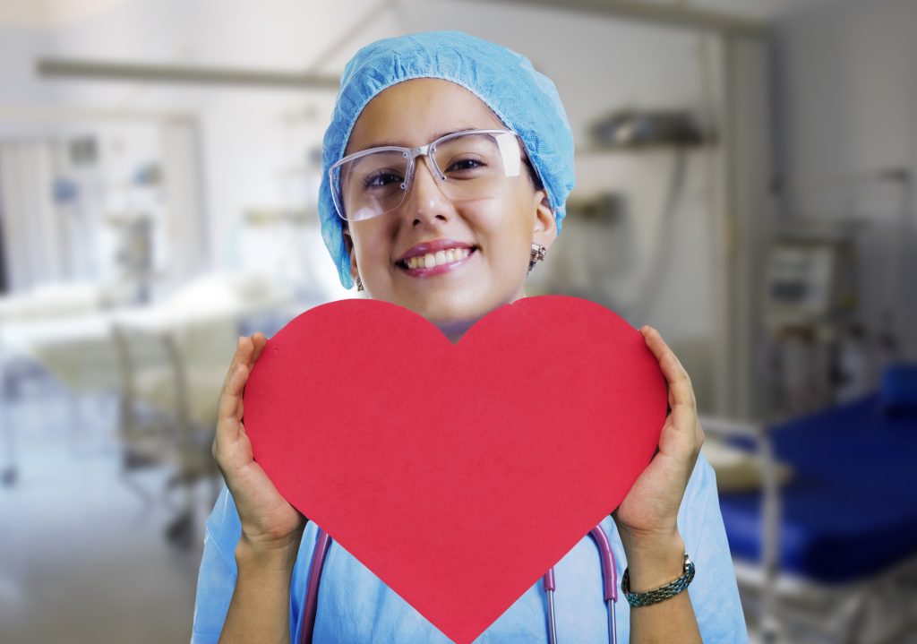 Nurse Holding a Heart Cardboard Sign | Breast Cancer Car Donations