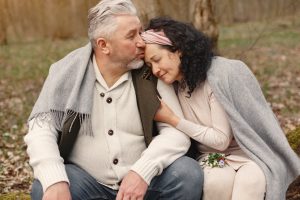 Happy senior couple hugging in autumn park | Breast Cancer Car Donations