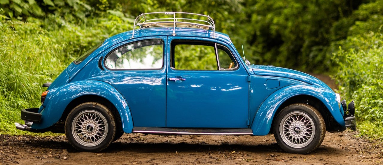 A Blue Volkswagen Beetle Parked Near Green Trees | Breast Cancer Car Donations