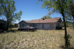 Black Car Parked Beside Brown House | Breast Cancer Car Donations