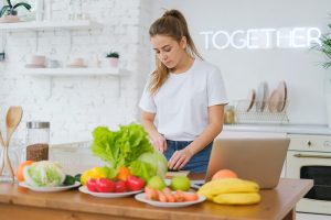 Woman Standing at Table with Vegetables | Breast Cancer Car Donations