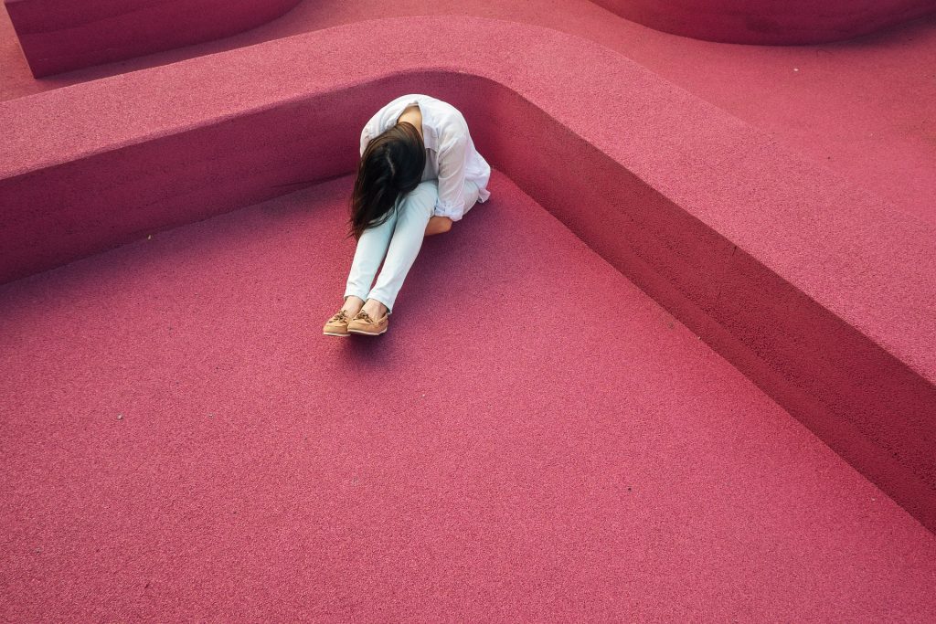 Sad Girl Sitting on a Pink Floor | Breast Cancer Car Donations