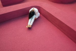 Sad Girl Sitting on a Pink Floor | Breast Cancer Car Donations