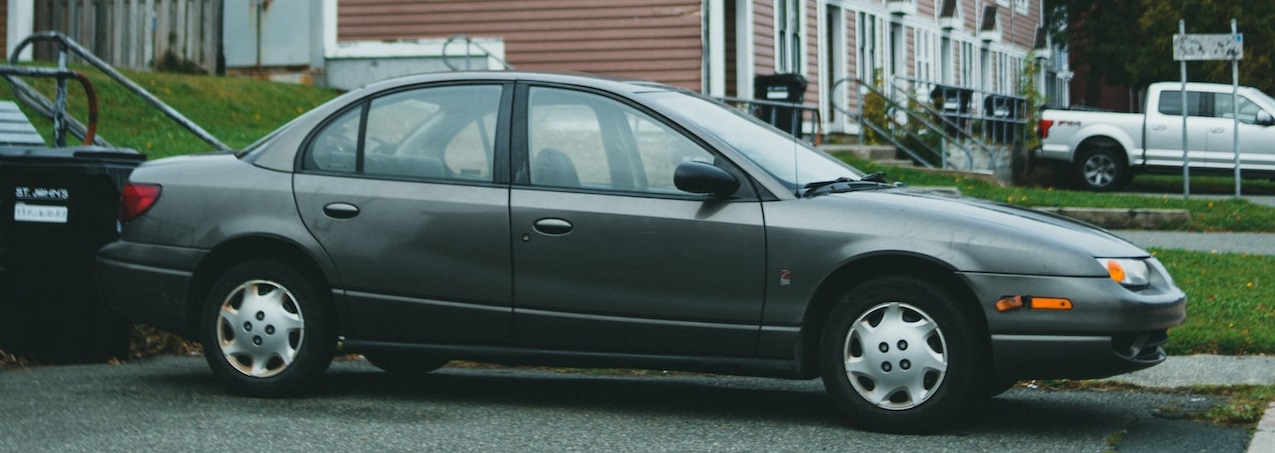 Black Sedan parked near house | Breast Cancer Car Donations