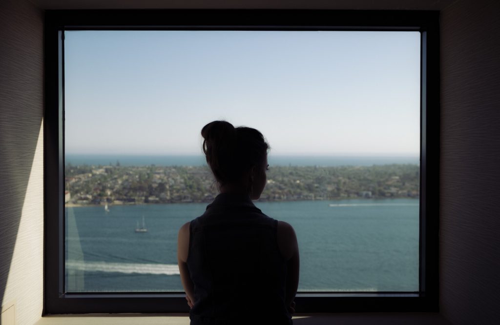 Woman Looking Outside the Window | Breast Cancer Car Donations