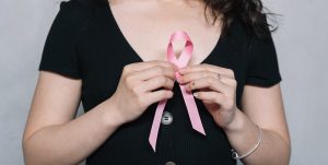 Woman holding pink ribbon | Breast Cancer Car Donations