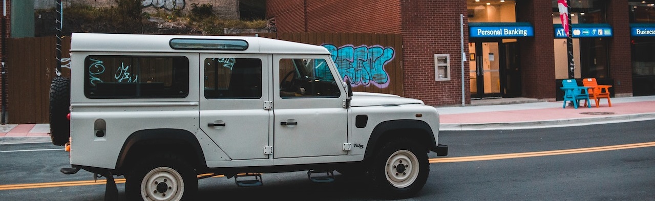 White jeep SUV on road | Breast Cancer Car Donations