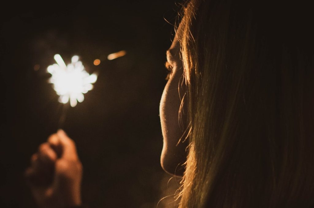 Woman Holding a Sparkler on New Year's Eve | Breast Cancer Car Donations