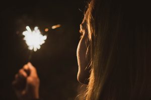 Woman Holding a Sparkler on New Year's Eve | Breast Cancer Car Donations