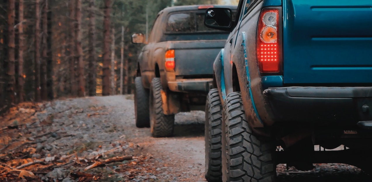 Two pick up truck in forest | Breast Cancer Car Donations