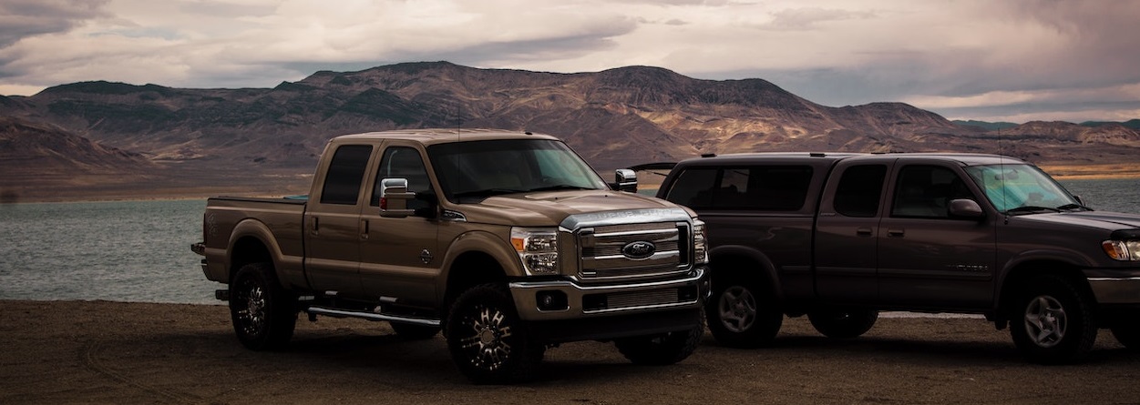 Two pick up trucks on sand | Breast Cancer Car Donations