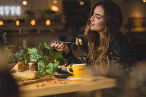Woman Enjoying Food on the Table | Breast Cancer Car Donations