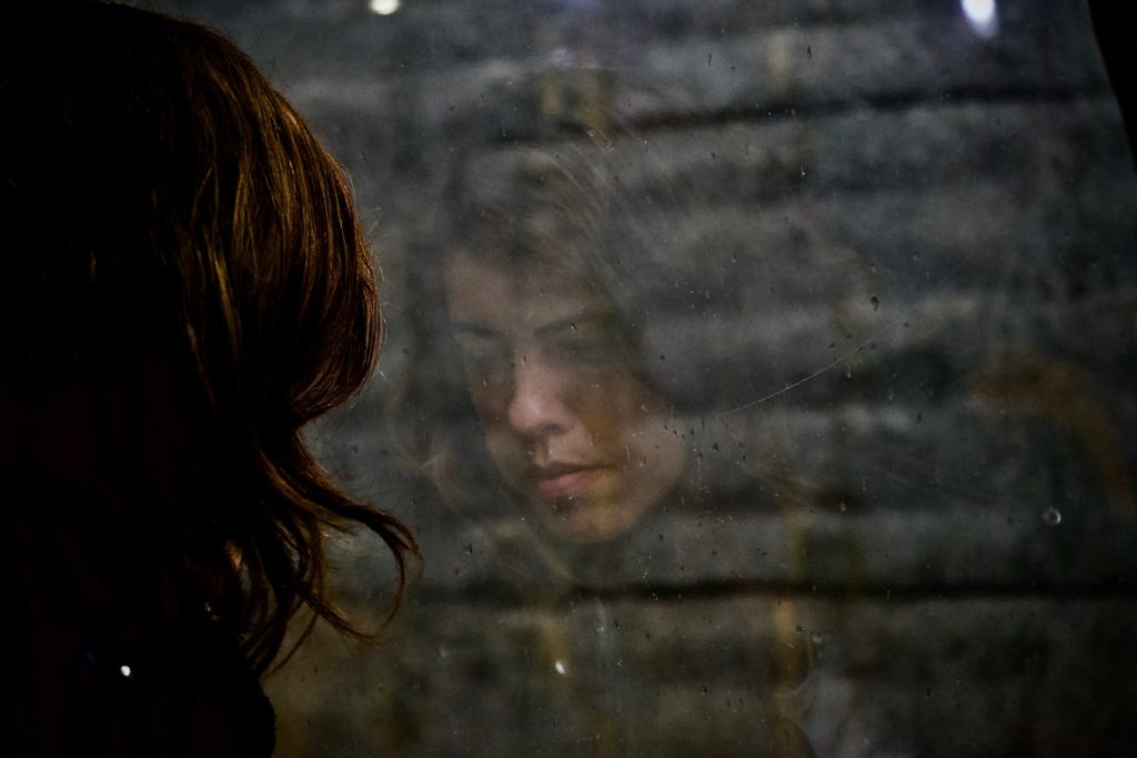 Anxious Woman Looking at a Glass Window | Breast Cancer Car Donations
