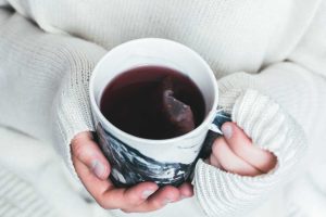 Person Holding a Cup of Tea | Breast Cancer Car Donations
