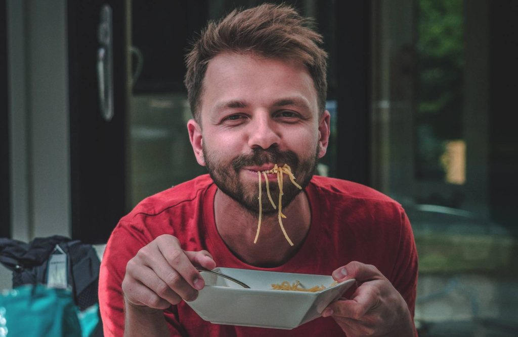 Person Enjoying a Bowl of Noodles | Breast Cancer Car Donations