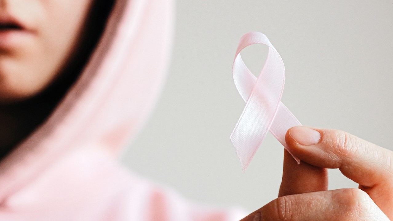 Woman Holding Pink Ribbon | Breast Cancer Car Donations