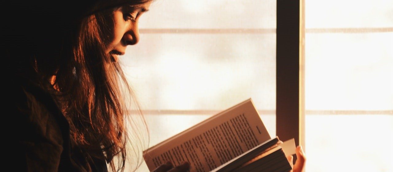 Woman Reading a Book Beside the Window | Breast Cancer Car Donations