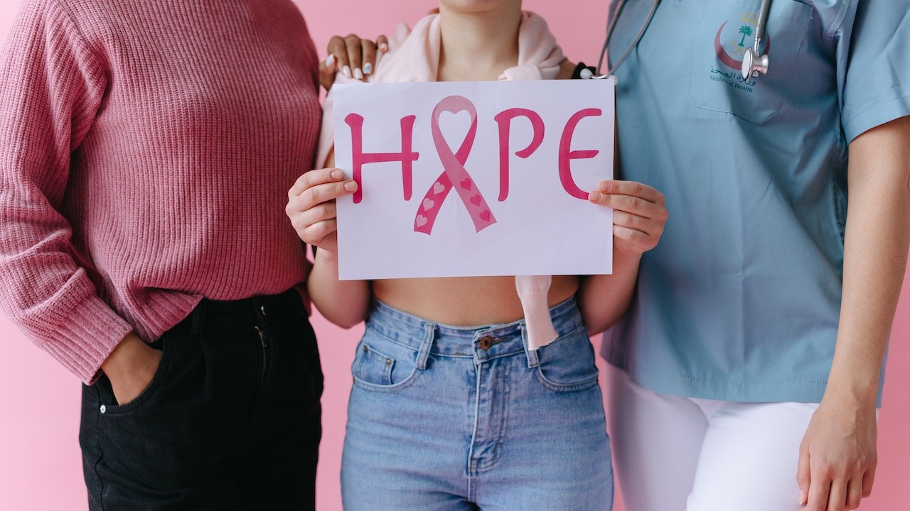 People with a Person Holding a Breast Cancer Awareness Placard | Breast Cancer Car Donations