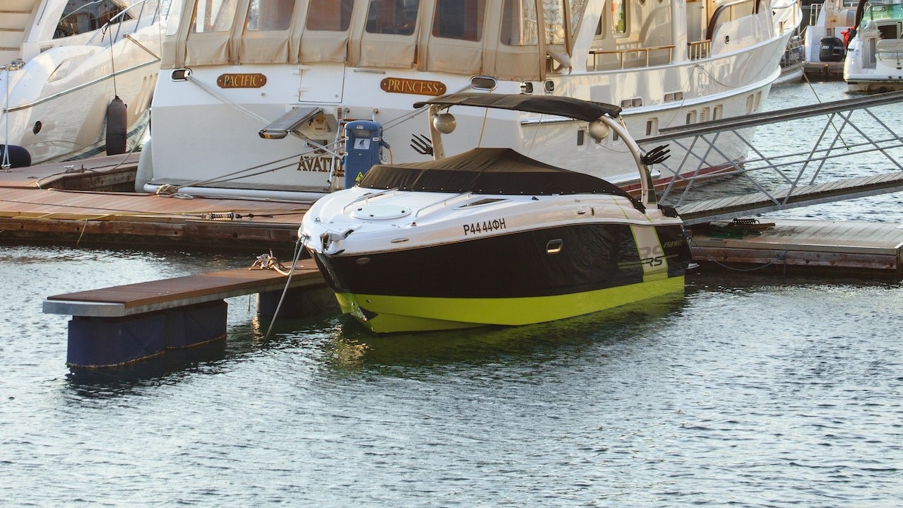 White Yacht Parked on Wooden Dock | Breast Cancer Car Donations