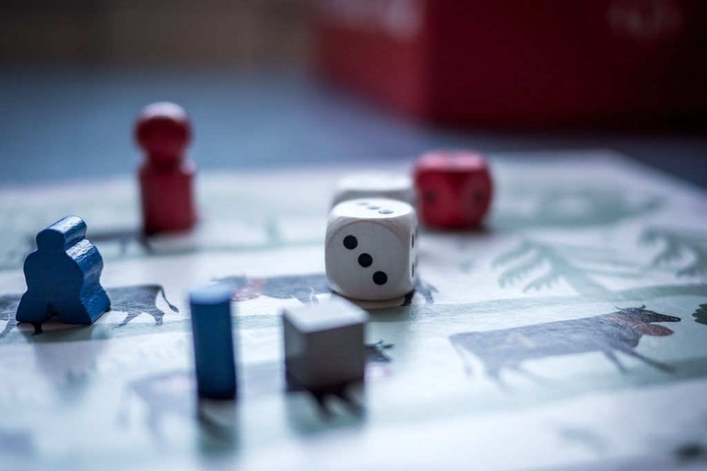 Dices and Wooden Pieces on Game Board | Breast Cancer Car Donations