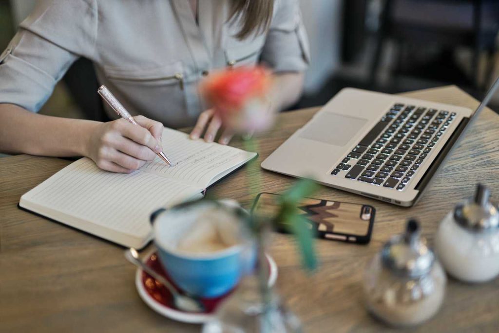 Woman Journaling on a Table | Breast Cancer Car Donations