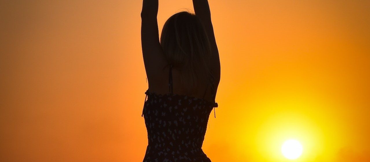 Carefree Woman In Long Dress Standing on A Rice Field During Sunset | Breast Cancer Car Donations