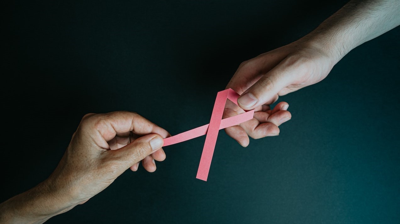 Hands Holding Breast Cancer Pink Paper Ribbon | Breast Cancer Car Donations