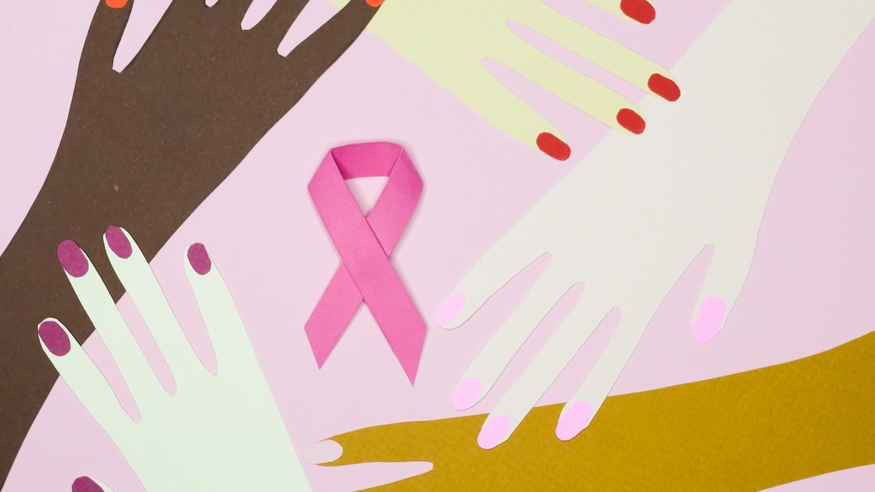 Paper Cutouts of Hands on a Pink Background | Breast Cancer Car Donations