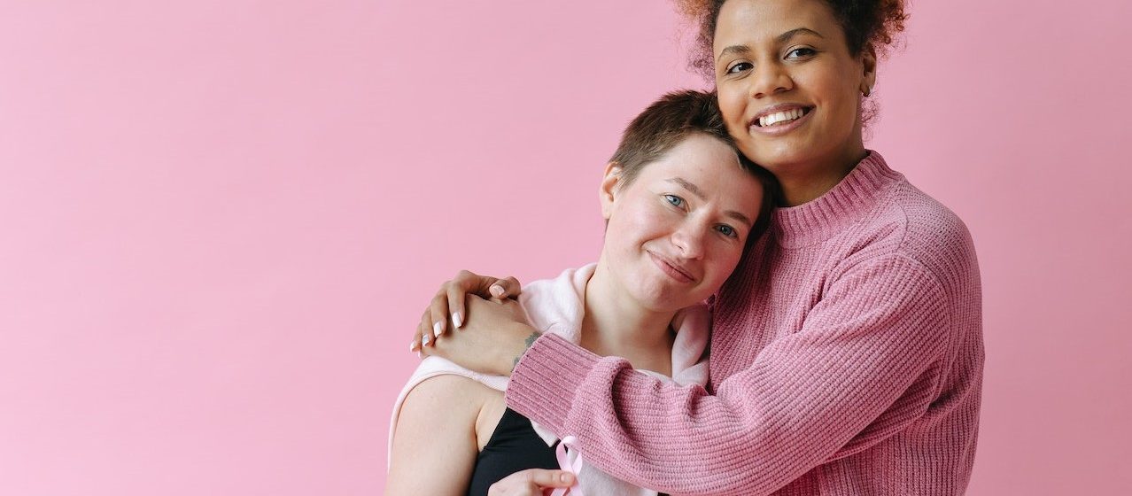 Women in Black Tank Top Holding Pink Ribbons | Breast Cancer Car Donations