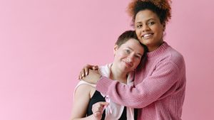 Women in Black Tank Top Holding Pink Ribbons | Breast Cancer Car Donations