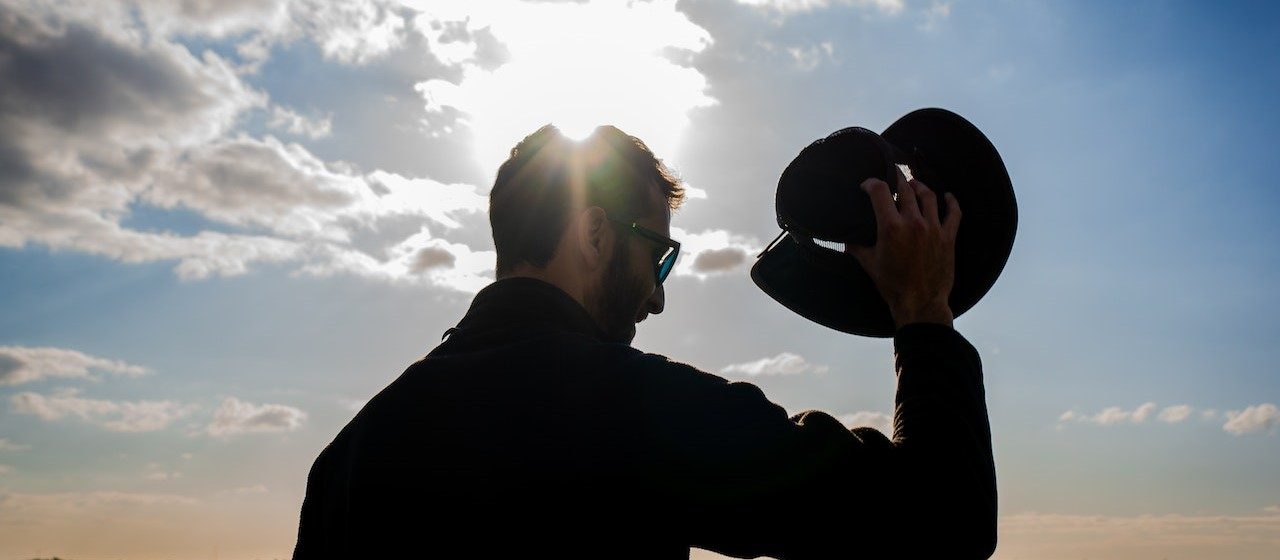 Silhouette of Man Holding a Hat | Breast Cancer Car Donations