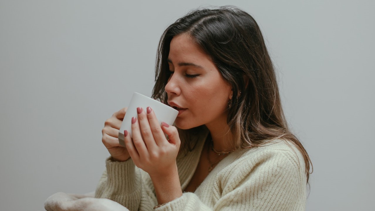 A Woman Sipping Tea From a Cup | Breast Cancer Car Donations