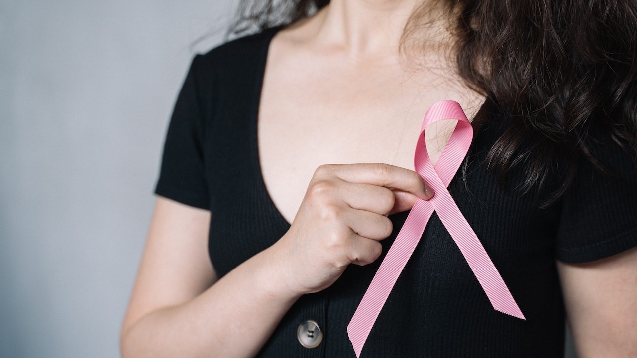Woman Holding Pink Ribbon | Breast Cancer Car Donations