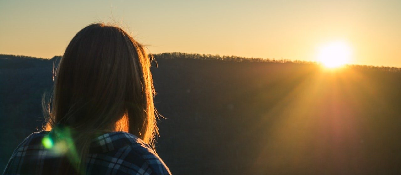 Woman Wearing Plaid Shirt Facing Sun during Golden Hour | Breast Cancer Car Donations