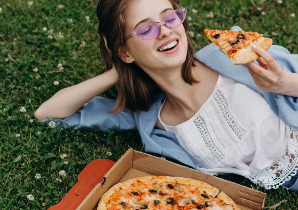 Woman Enjoying Box of Pizza | Breast Cancer Car Donations
